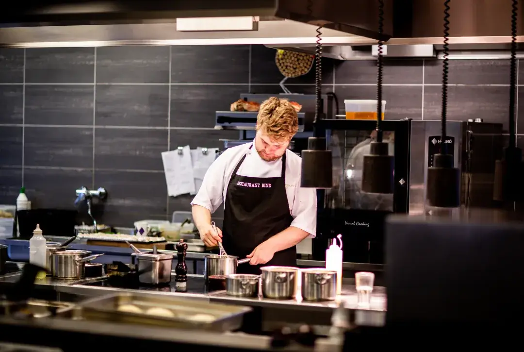 A chef plating with care in a professional kitchen
